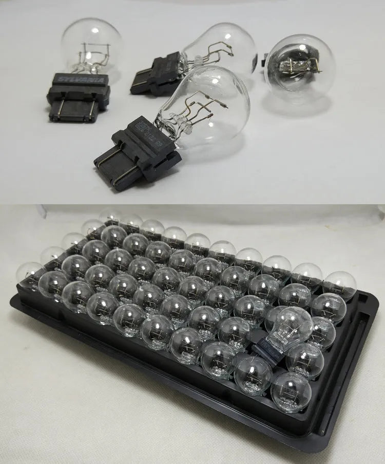 Wagner dual-wire brake light bulb with yellow glass and plastic orientation dot.