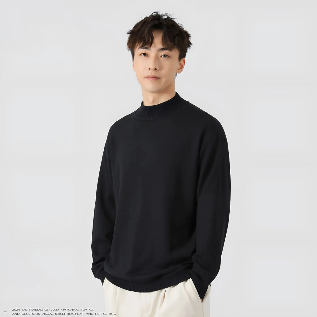 A man wearing a loose-fitting solid colour long sleeve casual pullover sweater.