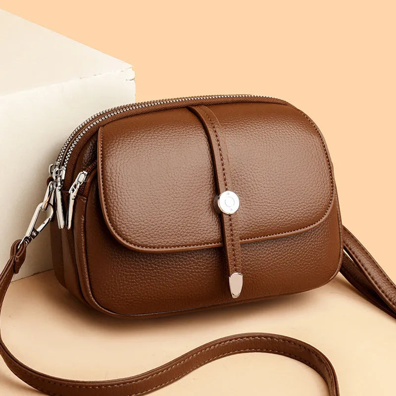Soft black oval crossbody shoulder bag for women with visible stitching and a shoulder strap.