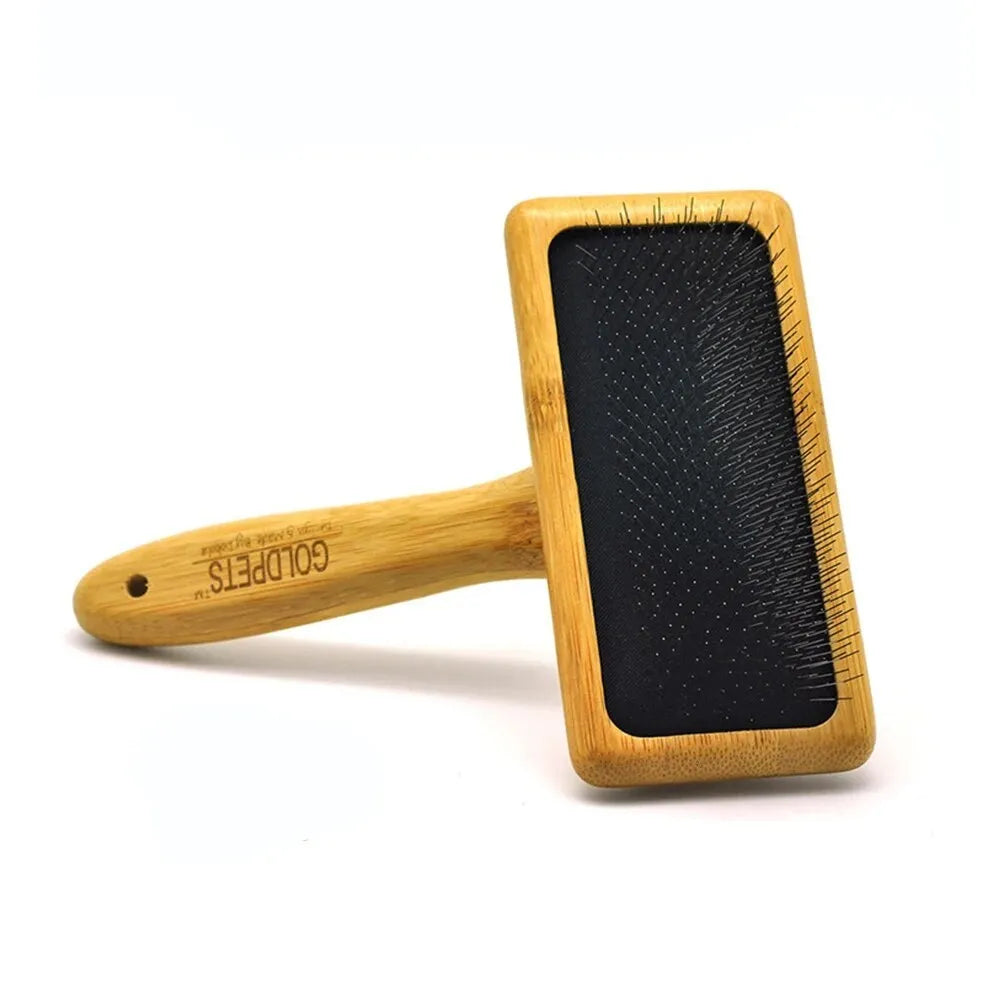 Goldpets bamboo handle pet slicker brush with stainless steel pins on wooden surface