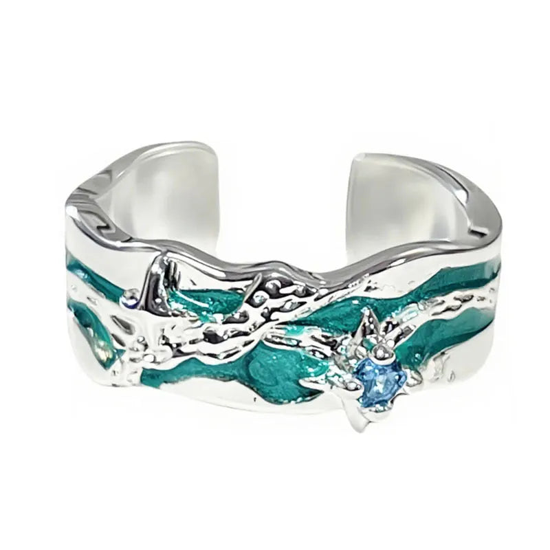 Mint green enamel asterism ring with copper folding geometric design on a hand.