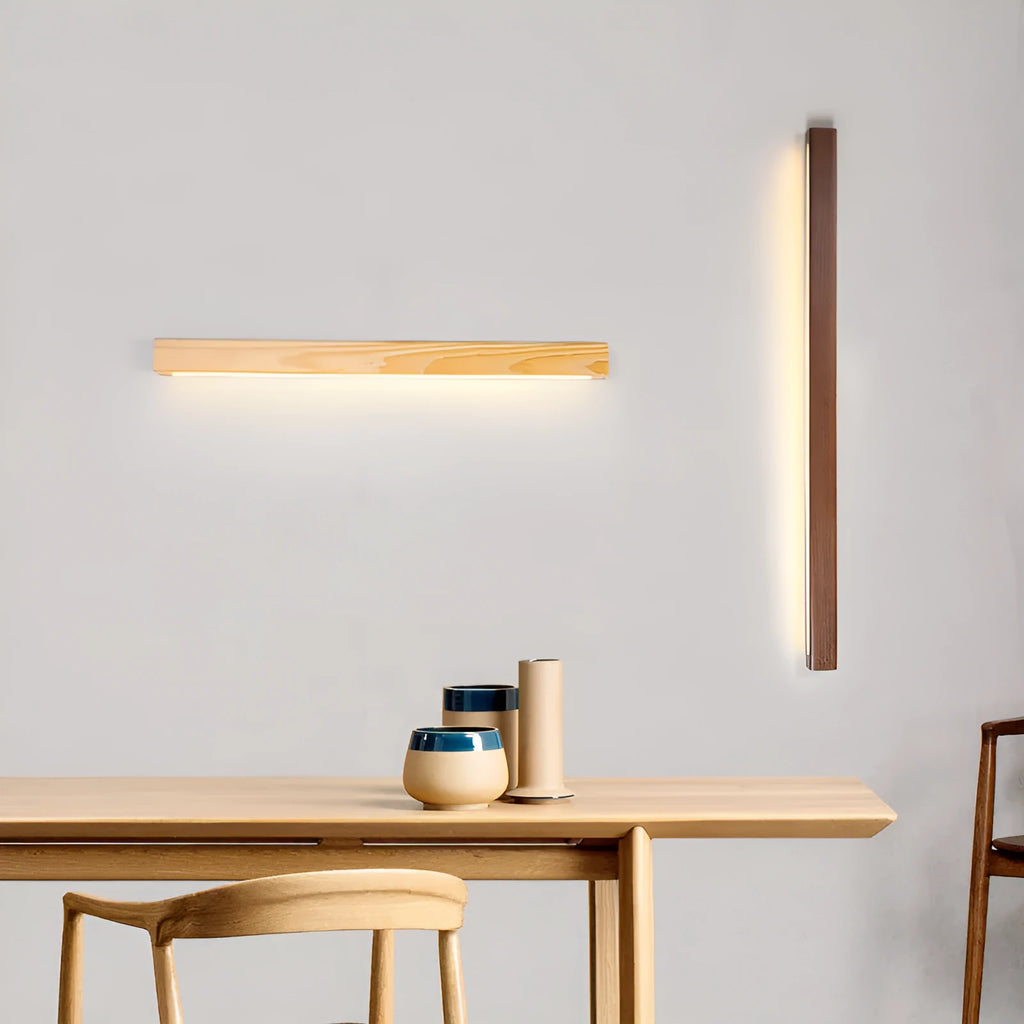 Slim walnut-coloured wood and acrylic LED strip wall lamp mounted on a wall in a modern room.