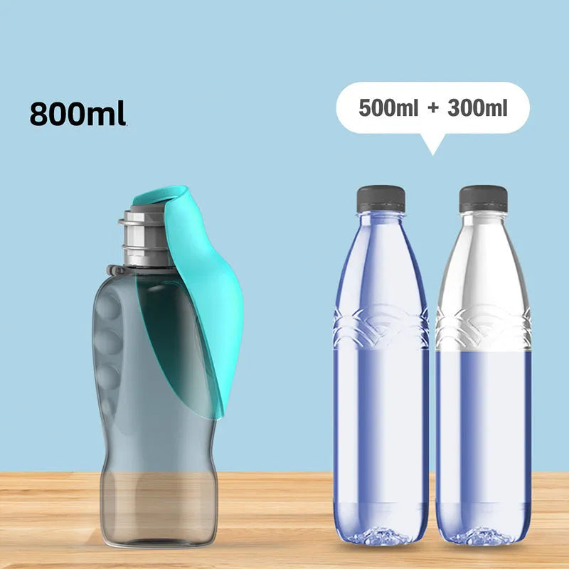Blue-grey foldable dog water bottle with drinking trough open, showing wrist strap and lock key.
