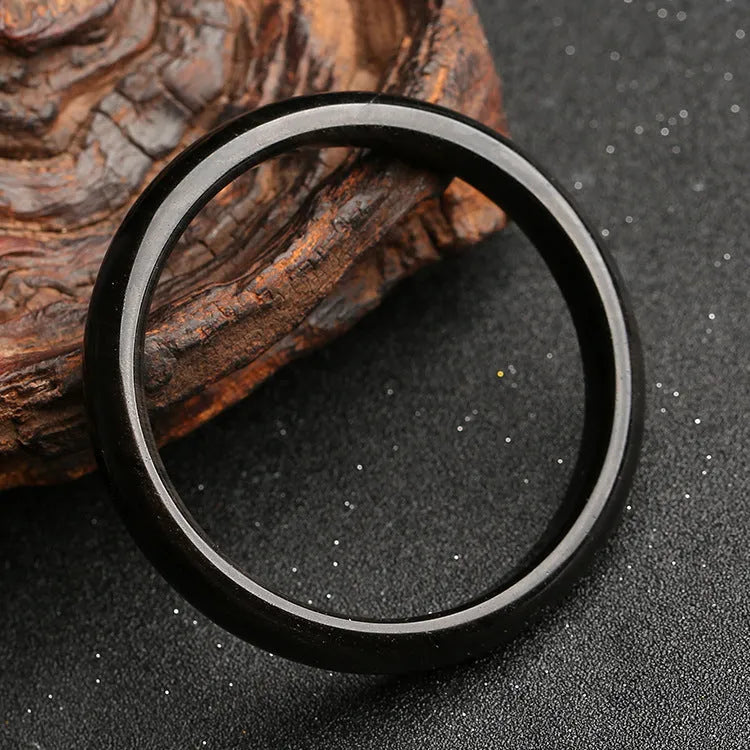 Ethnic geometric obsidian cat's eye bracelet in silver stone colours on a wrist.