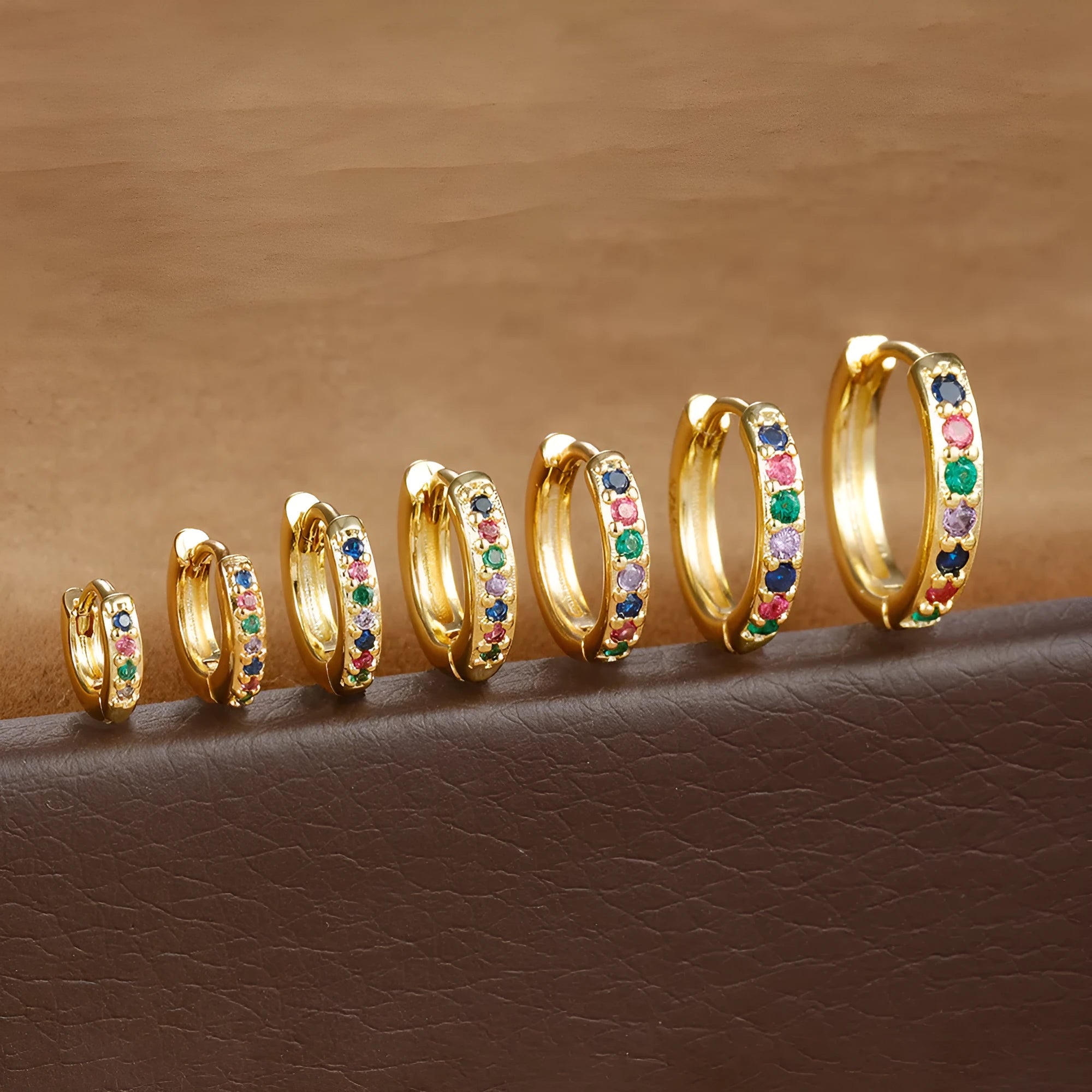 Circular perforated stud earrings in gold, rose gold, and silver colours on a copper base.
