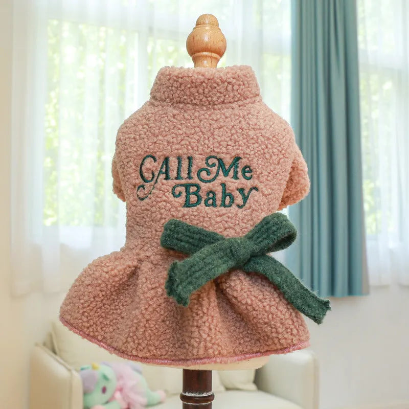 Pet dog wearing a pink baby letter patterned fleece skirt, showing the casual fit and soft polyester material.
