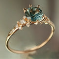 Gold plated geometric ring with a claw-set zircon stone and a textured square pattern on the band.