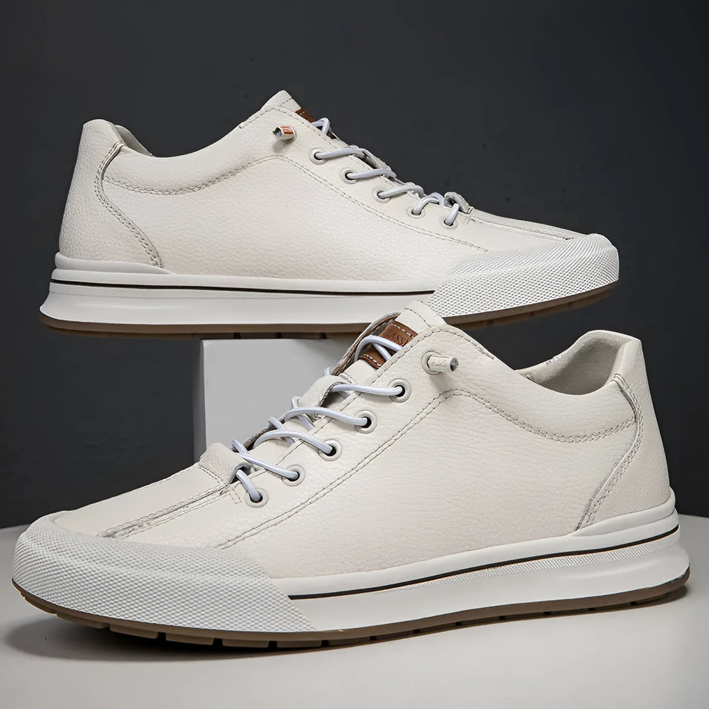 Men's white and black leather round toe flat casual trainers on a plain background.