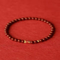 Natural cinnabar koi bracelet with golden balls in national style, showing sand grain texture
