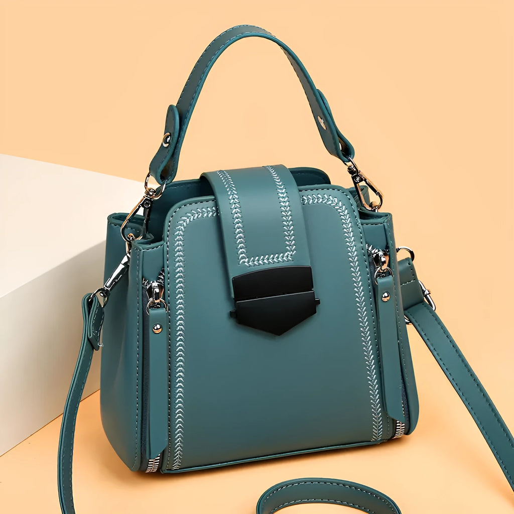 Small square vertical handbag in soft textured PU leather with sewing thread detail.