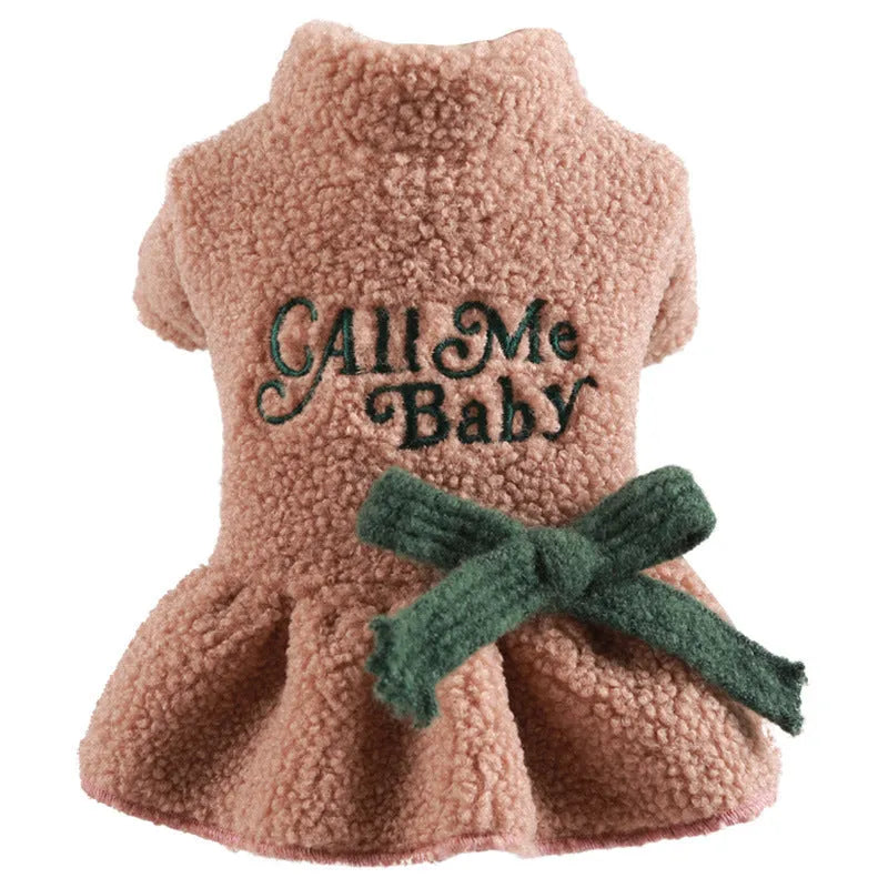 Pet dog wearing a pink baby letter patterned fleece skirt, showing the casual fit and soft polyester material.