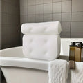 White 4D mesh bathtub pillow with suction cups on a bathtub edge.