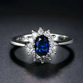 Women's flower-shaped moissanite ring in electroplated copper, shown in sapphire blue colour on a hand.