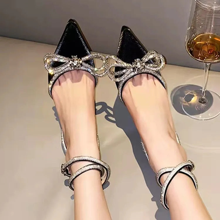Women's black stiletto heel sandals with a silk back bandage and buckle fastening, shown from the side.