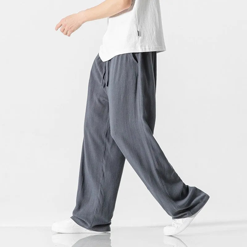 Men's beige cropped linen trousers with a drawstring waist and straight-leg casual style on a hanger.