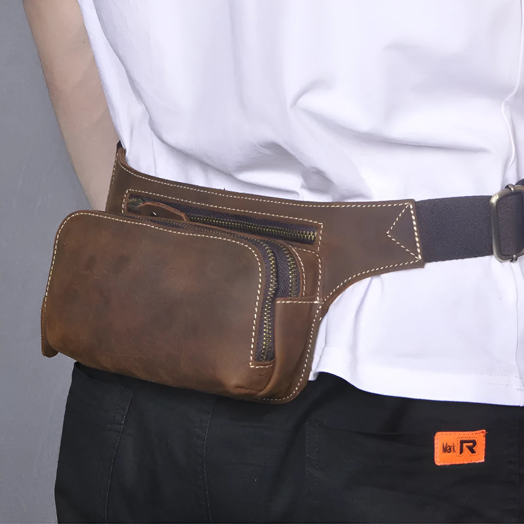 Brown cowhide leather men's waist bag with pull closure, shown with internal mobile phone compartment.