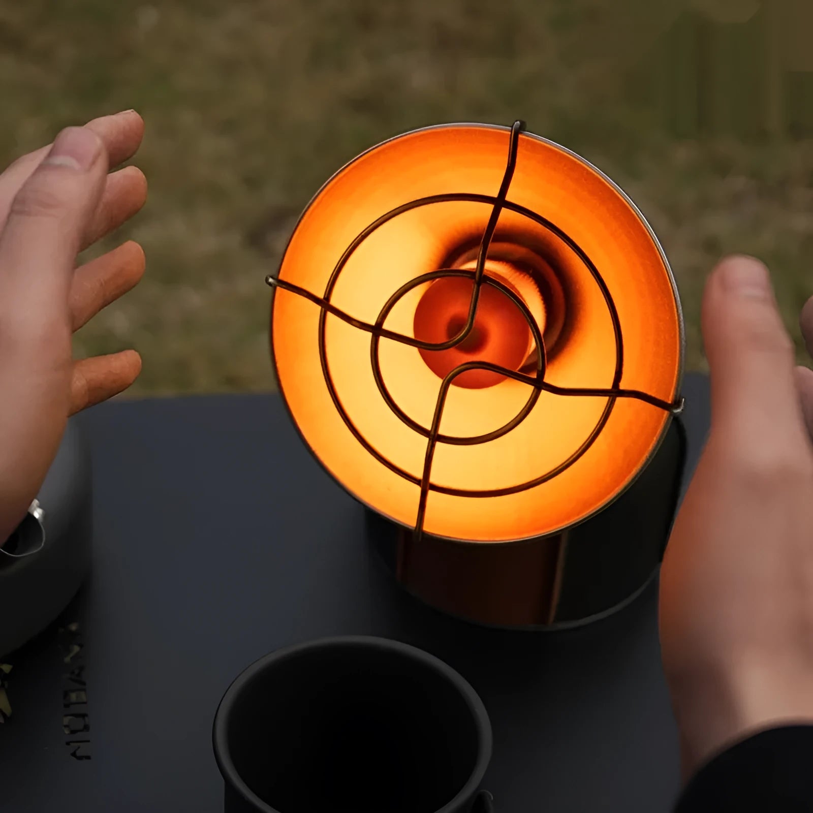Portable outdoor heating stove with black and orange design showing automatic press ignition