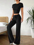 Black women's polyester tracksuit set with short sleeve top and high-waist trousers.
