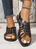 Black Roman style beach slippers with cross straps and flat buckle closure on open toe design