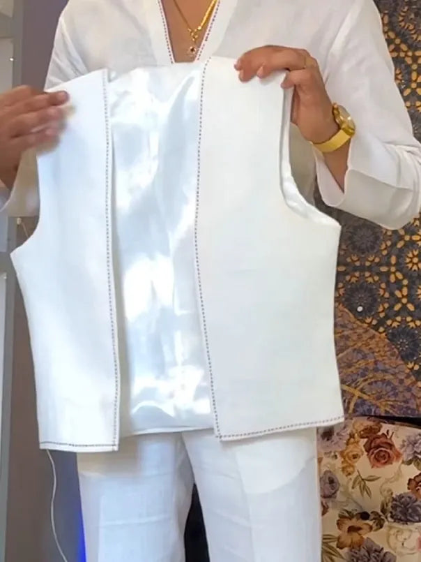 White three-piece outfit showing V-neck shirt, sleeveless vest, and full-length trousers laid flat