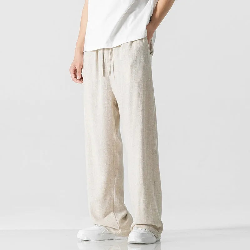 Men's beige cropped linen trousers with a drawstring waist and straight-leg casual style on a hanger.