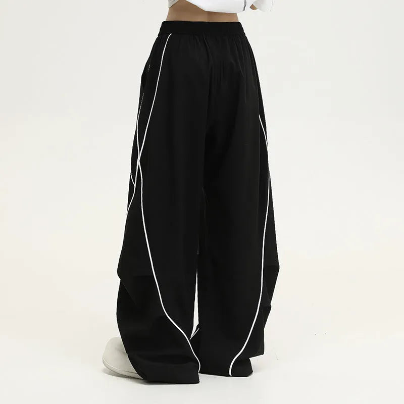 Black pleated wide-leg hip hop trousers with stripe pattern showing loose fit design