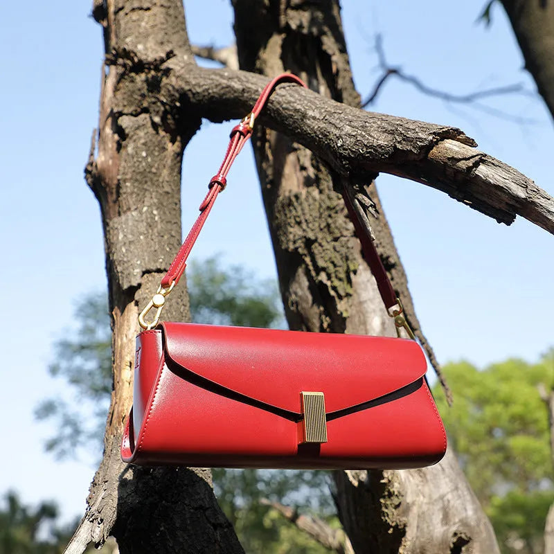 A pillow-shaped women's cowhide leather cross-body bag with a clamshell opening, shown in a choice of colours.