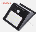 White solar-powered outdoor garden lamp with LED lights and a motion sensor on a black stake.