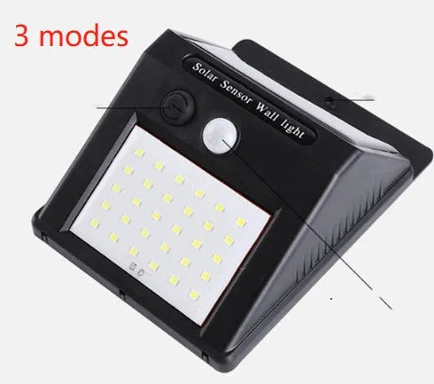 White solar-powered outdoor garden lamp with LED lights and a motion sensor on a black stake.
