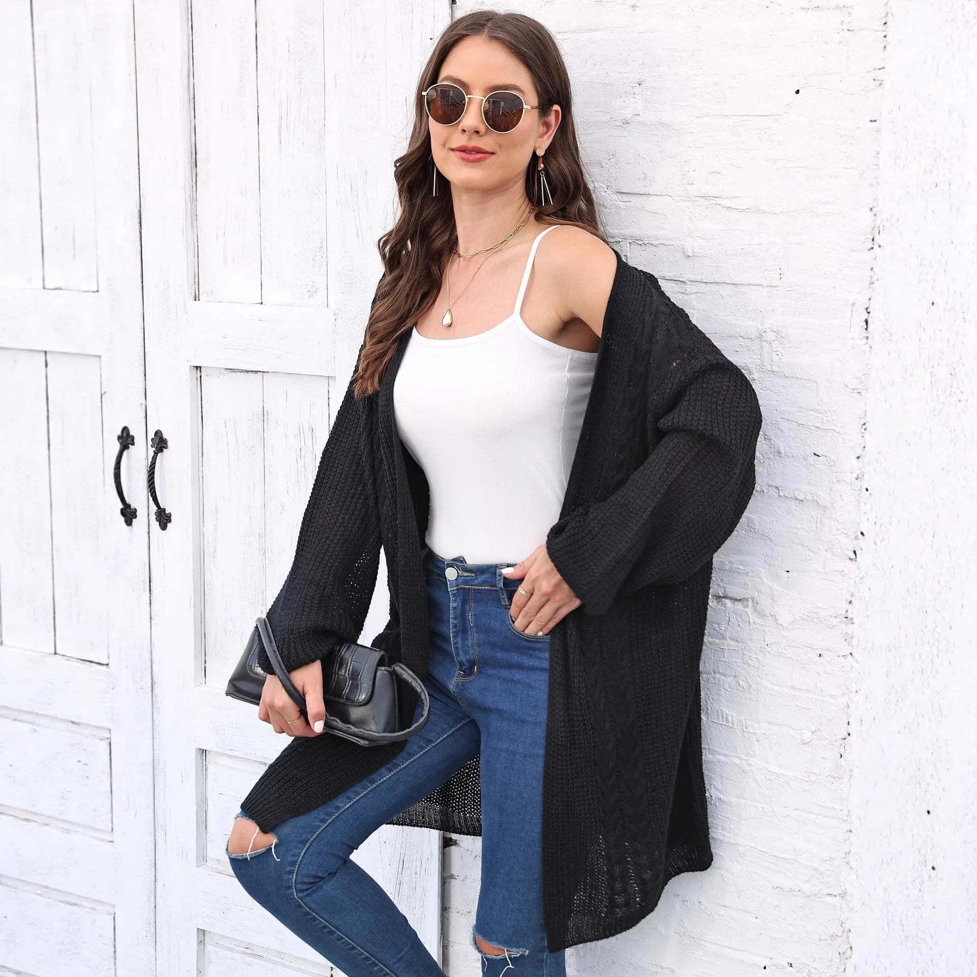 Women's loose brown acrylic sweater coat hanging, showing solid colour and knit texture.