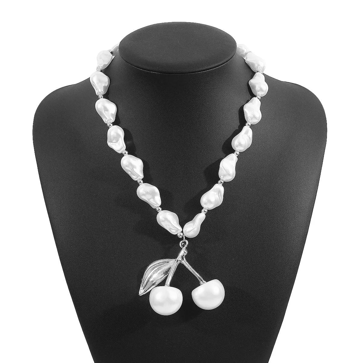 Gold coloured cherry fruit pendant necklace with imitation pearls on an adjustable chain.