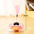 Pink cat tumbler turntable toy with interactive play stick on a flat surface.