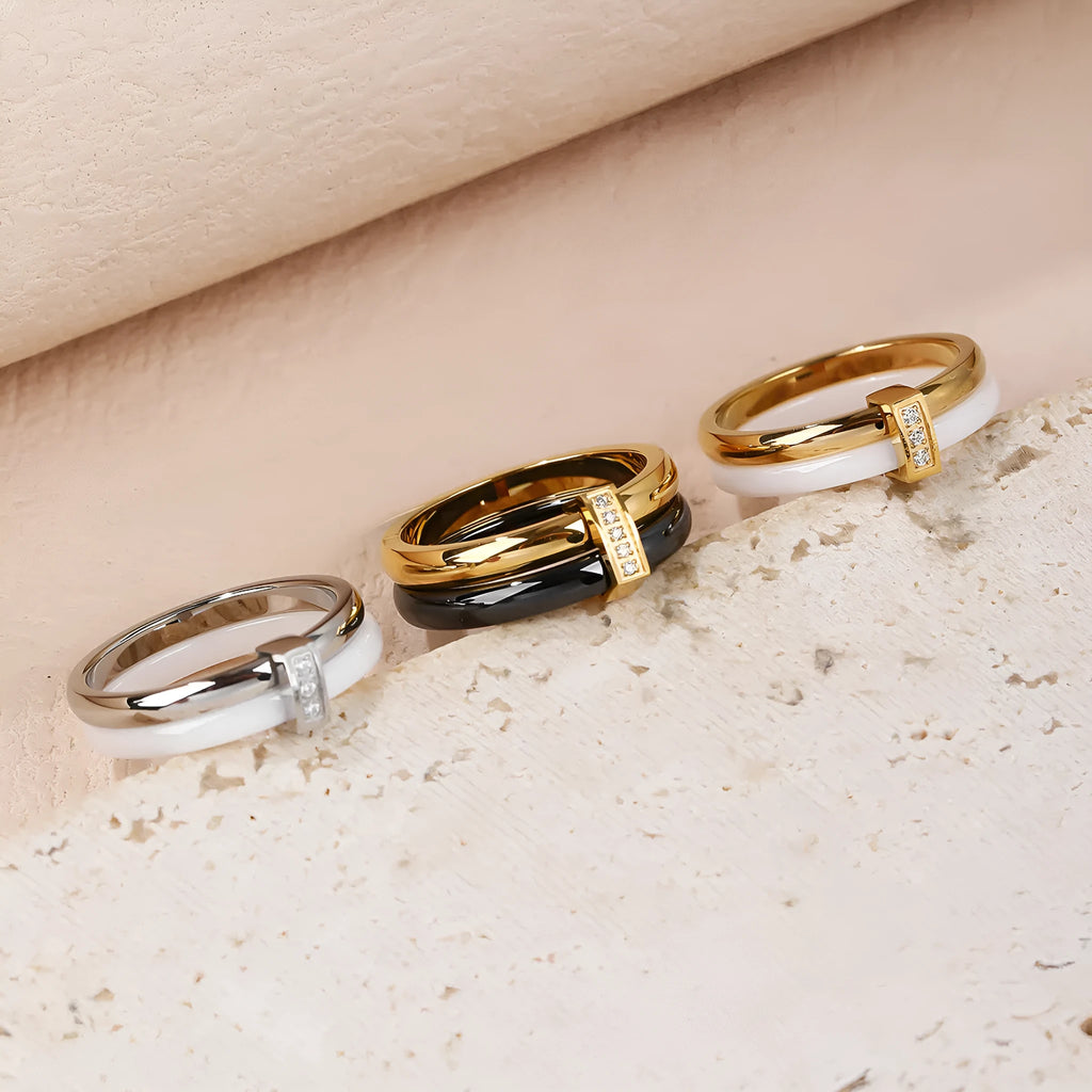 Glossy titanium steel women's ring with zirconium inlay in a heart shape on a double band.
