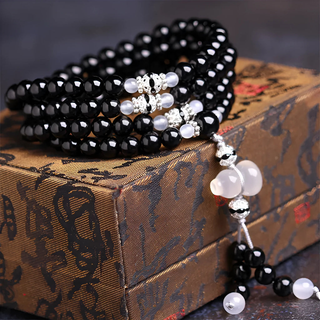 Black agate geometric bead bracelet with 108 beads and number details on a wrist.