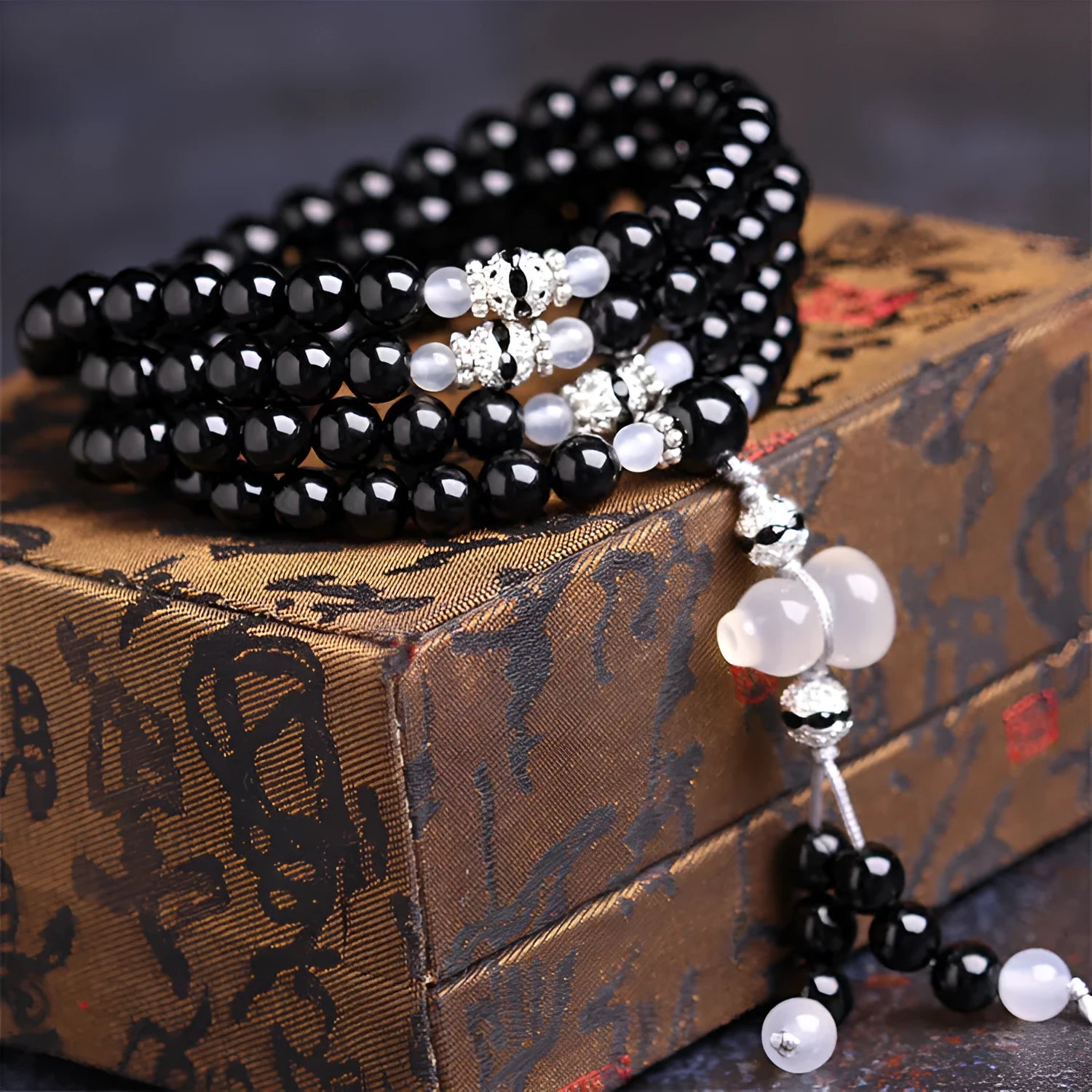 Black agate geometric bead bracelet with 108 beads and number details on a wrist.