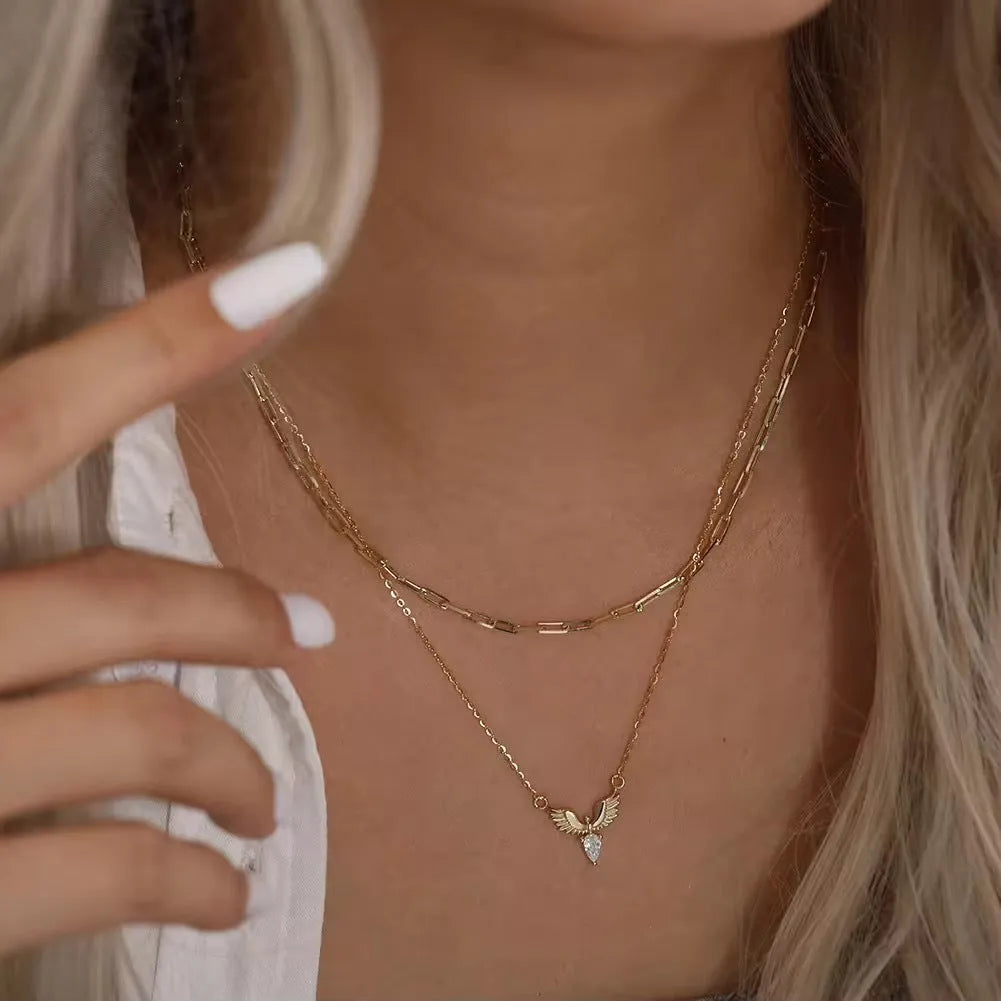 Close-up of a sterling silver eagle pendant necklace on an O-ring chain, showing white gold and yellow gold colour options.