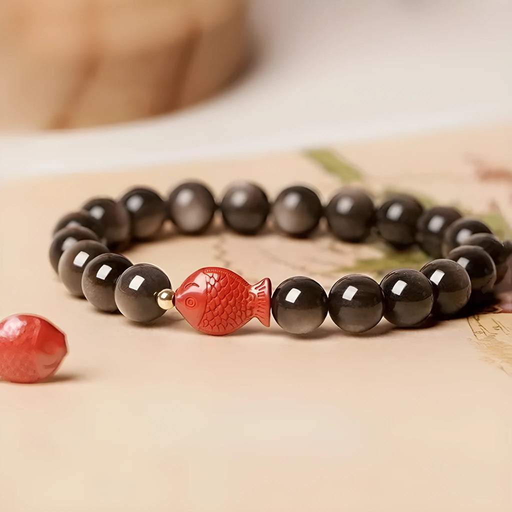 Natural obsidian round bead bracelet with red cinnabar fungus decorative elements.