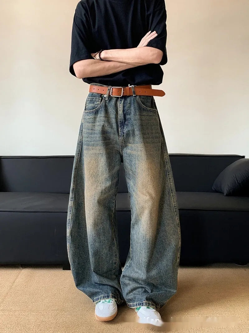 Retro blue men's distressed wide-leg jeans on a neutral background, showing machete detailing and mid-waist zip fly.