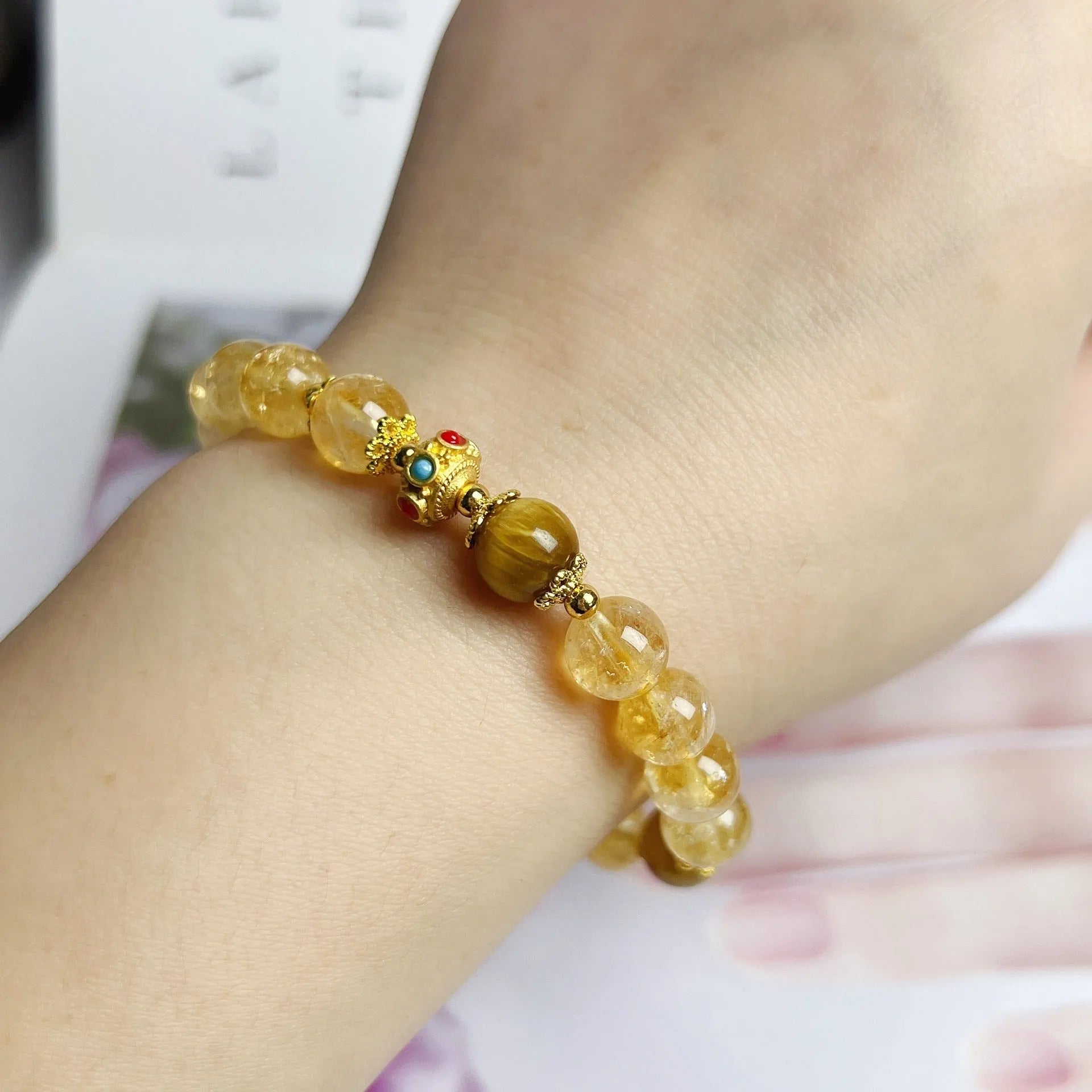 Golden yellow citrine crystal bracelet with flower and tassel detail for women.