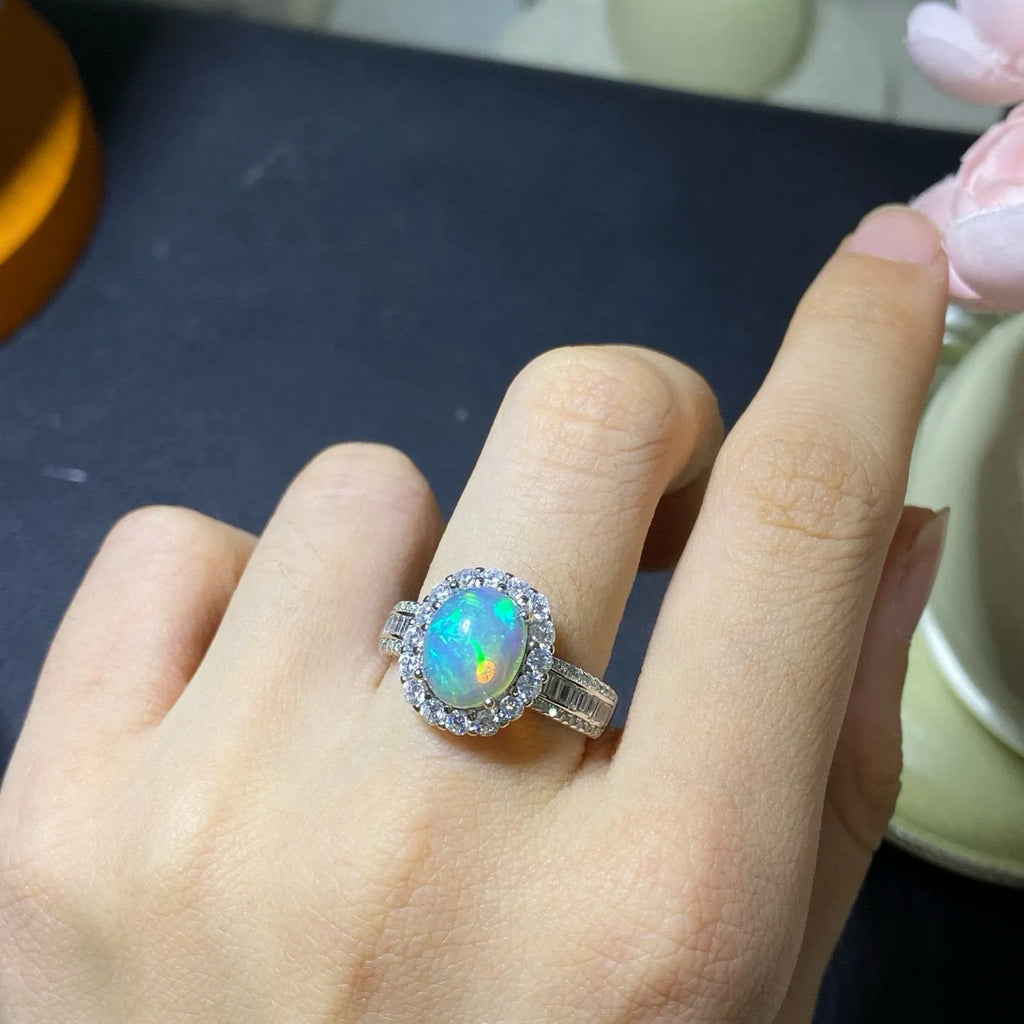 Adjustable opening opal ring in sterling silver with gold tone plating on a model's hand