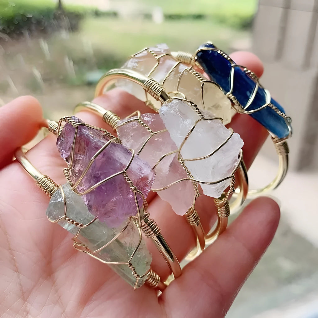 Unisex geometric bracelet with rough natural crystals and gold winding metal on a wrist.