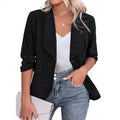 Slim-fitting black polyester suit jacket with long sleeves on a hanger.
