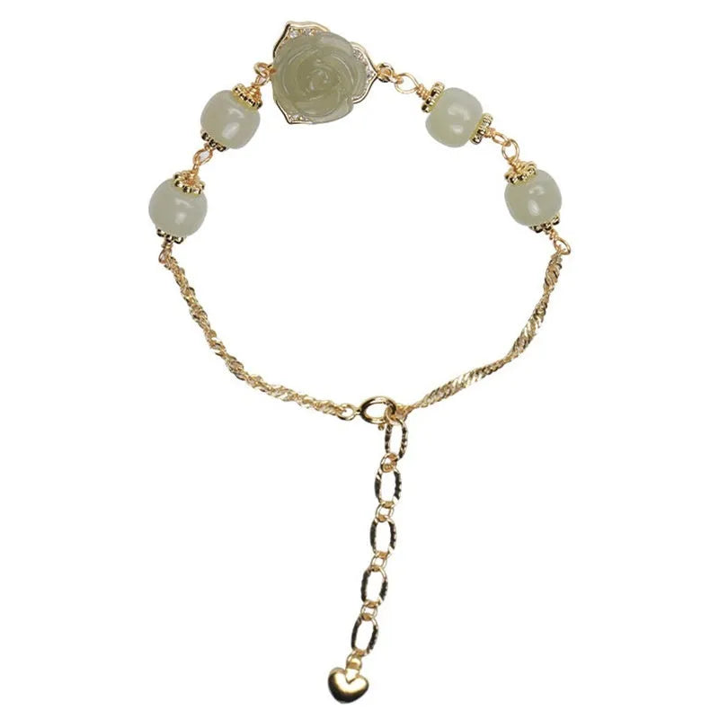 Close-up of a women's Hetian Jade bracelet with rose design and 14K gold gilding.