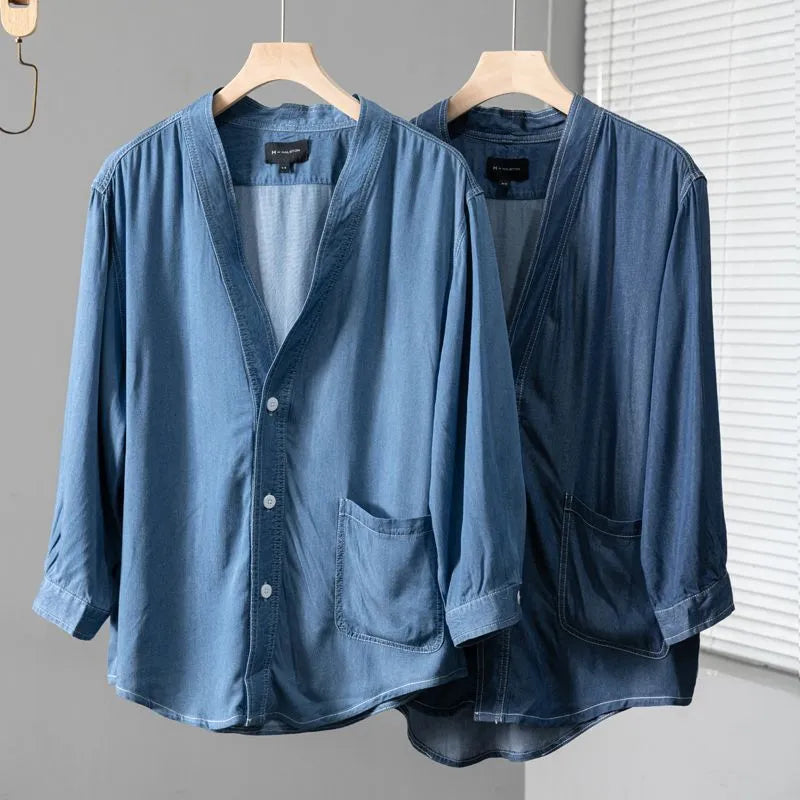 Men's dark blue denim coat with three-quarter sleeves and V-neck collar showing front pocket detail