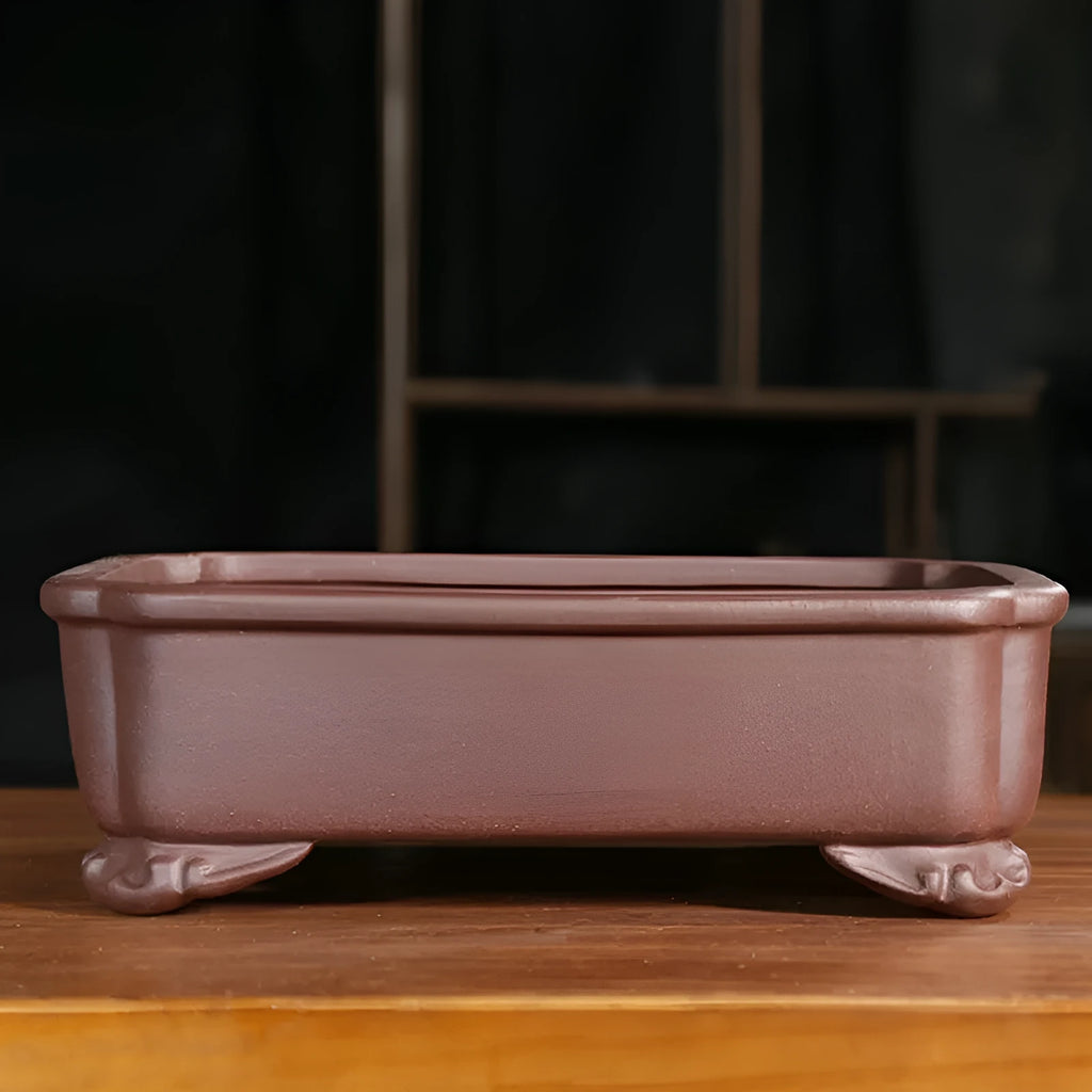 Classical rectangular purple sand bonsai pot with cut corners on a floor.