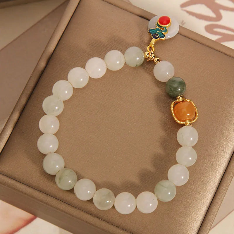 Close-up of a women's ice jade bracelet with a xiangyun peace buckle and pearl detail.