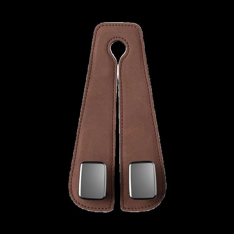 Black suede car seat hook attached to a headrest post, holding a shopping bag.