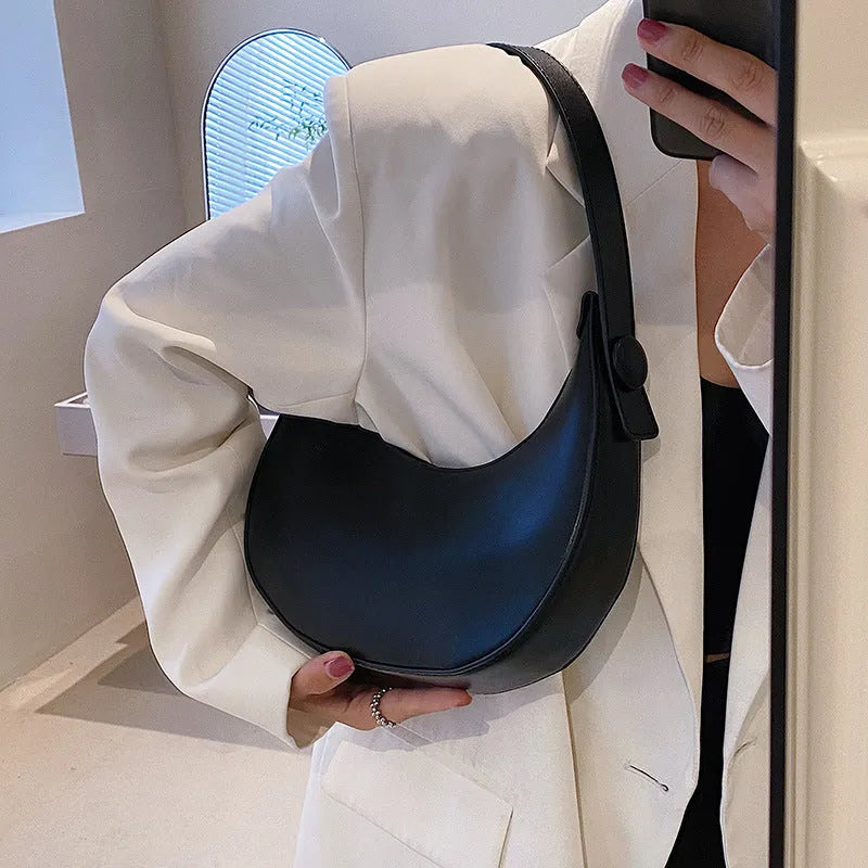 Retro dumpling-shaped black PU leather women's shoulder bag with a front sandwich pocket.