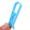 Green and black non-slip plastic clip for holding a bin bag on a wheelie bin rim.