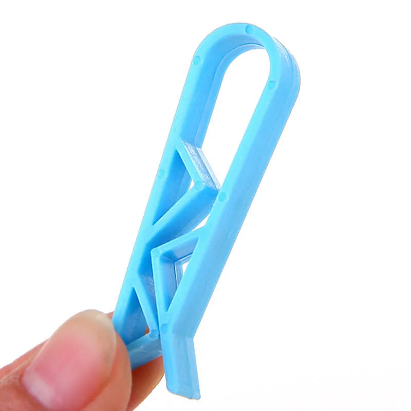 Green and black non-slip plastic clip for holding a bin bag on a wheelie bin rim.
